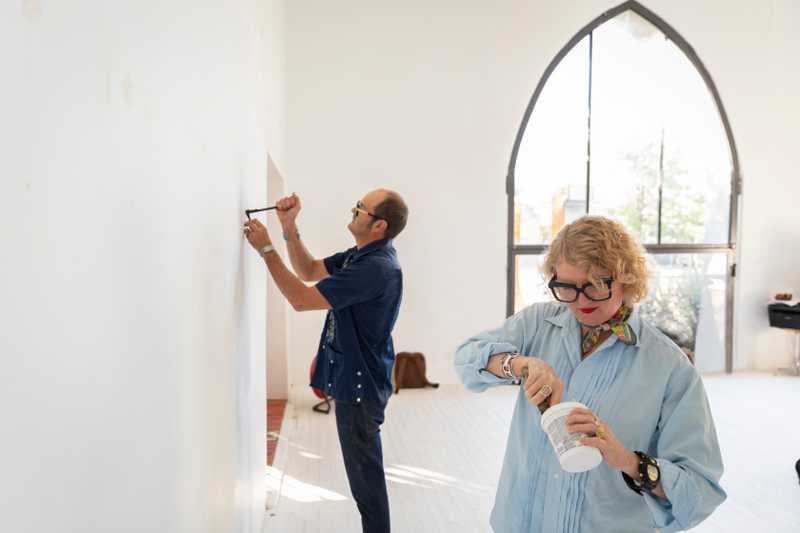 Man and woman painting a wall 