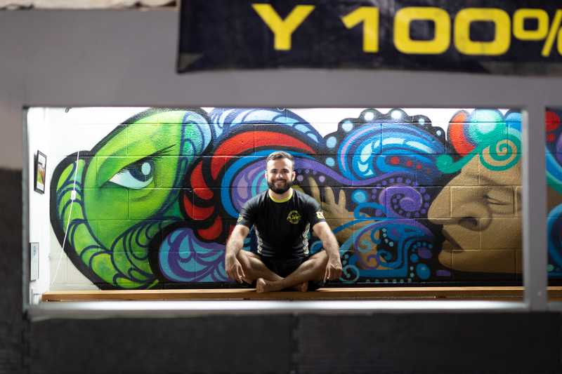 A man sitting down in front of graffiti wall